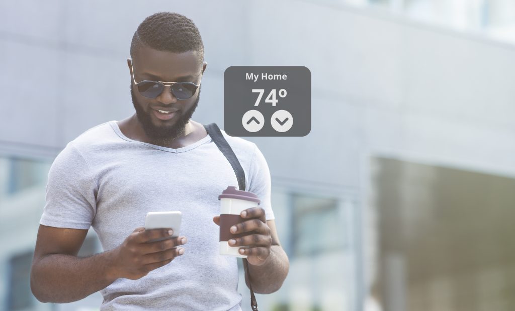 Young male looking at phone to use smart home tools for temperature control